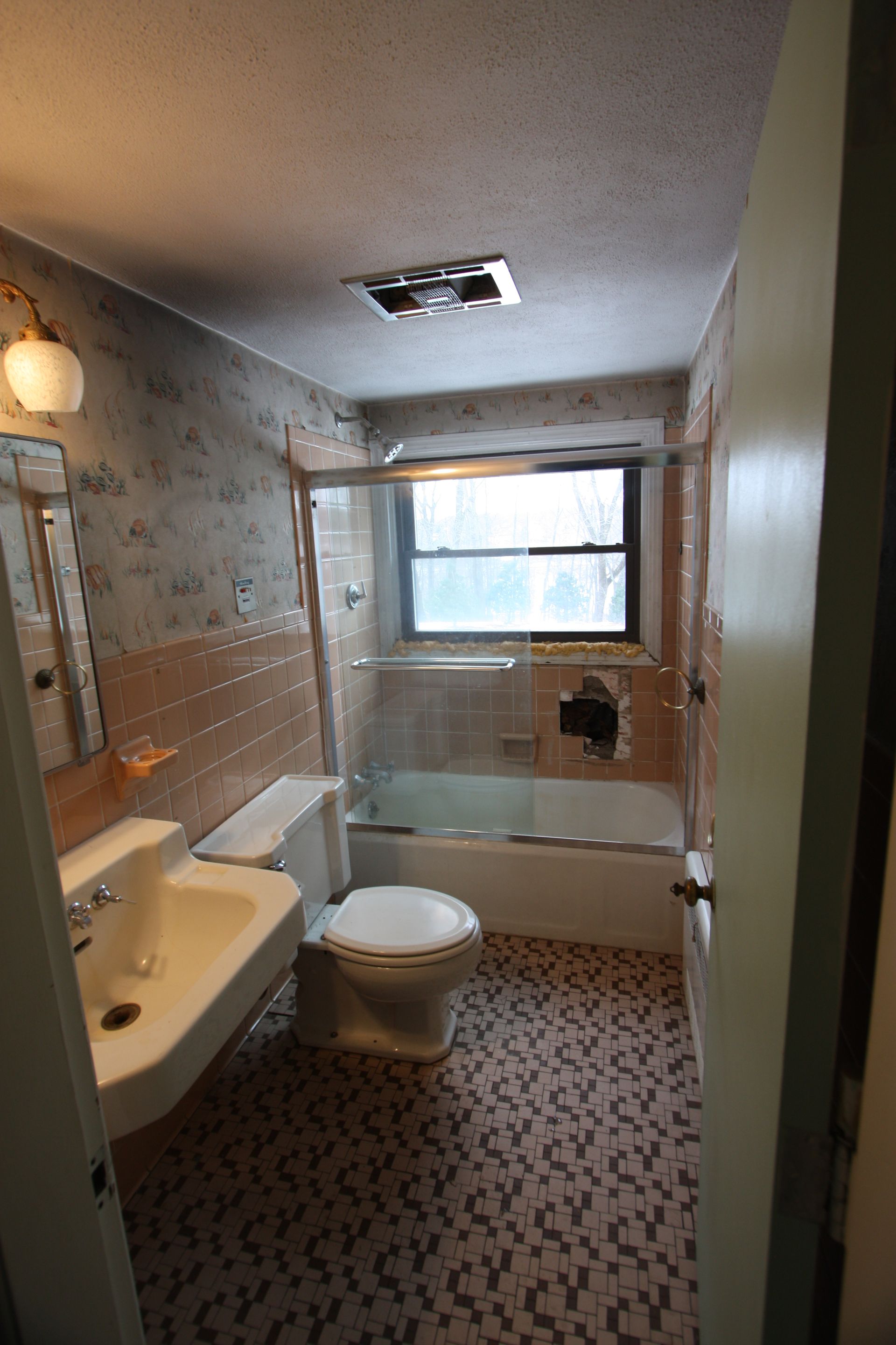 A bathroom with a toilet, sink, and bathtub.