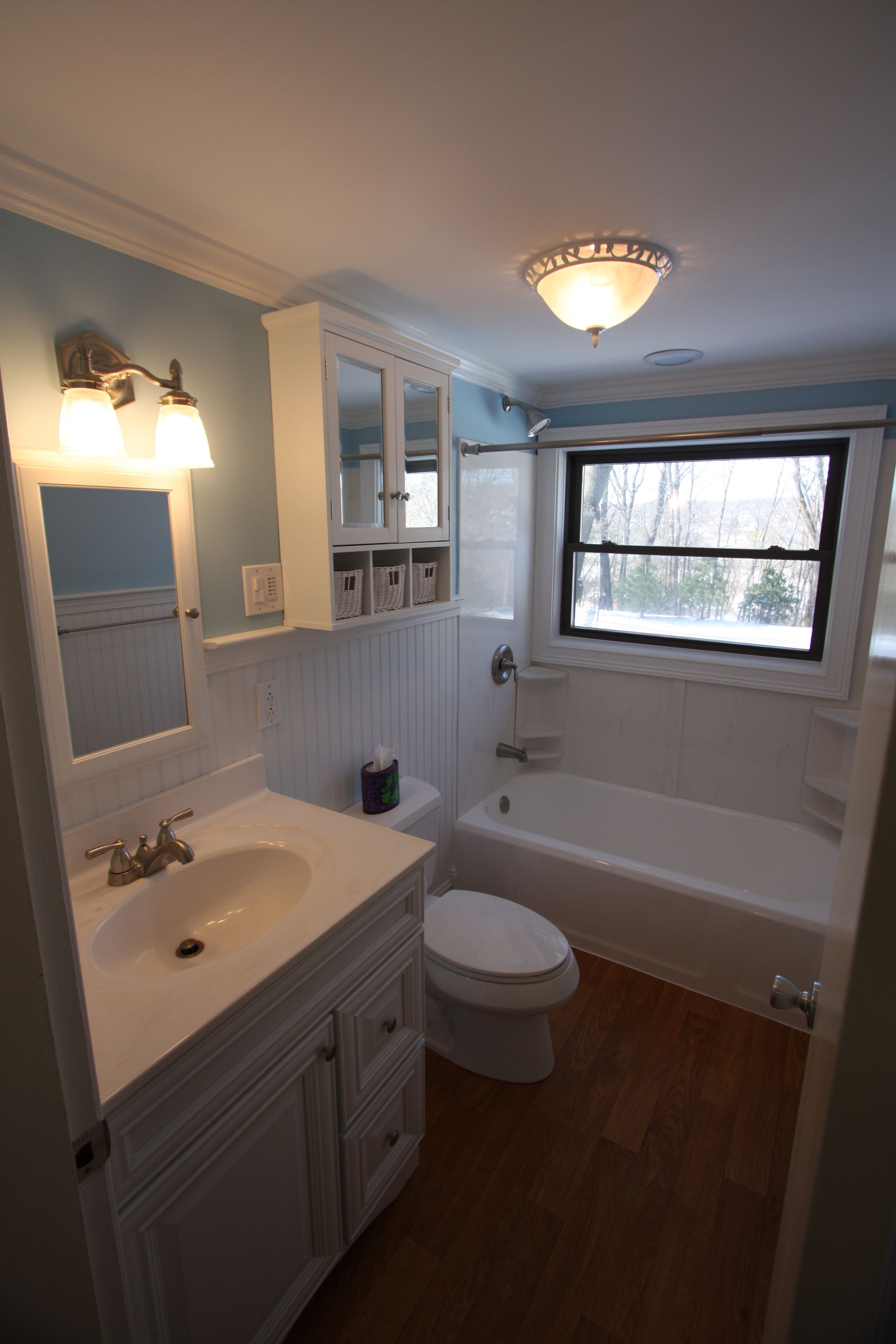 A bathroom with a sink, toilet, tub, and mirror.