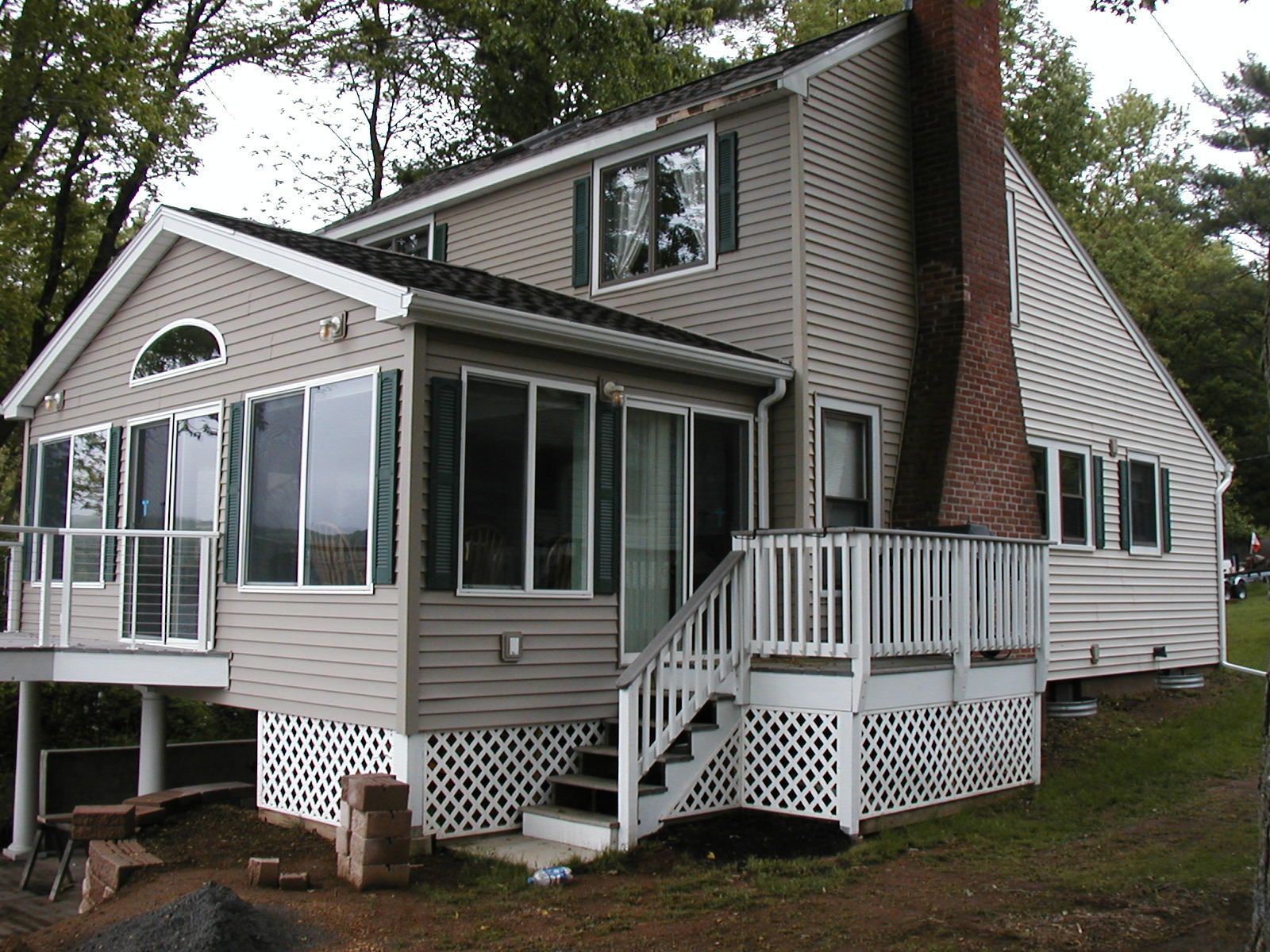 The back of a house with a large deck and stairs.