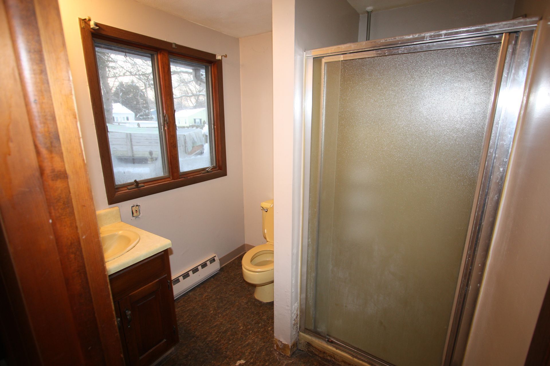 A bathroom with a toilet, sink, and shower.