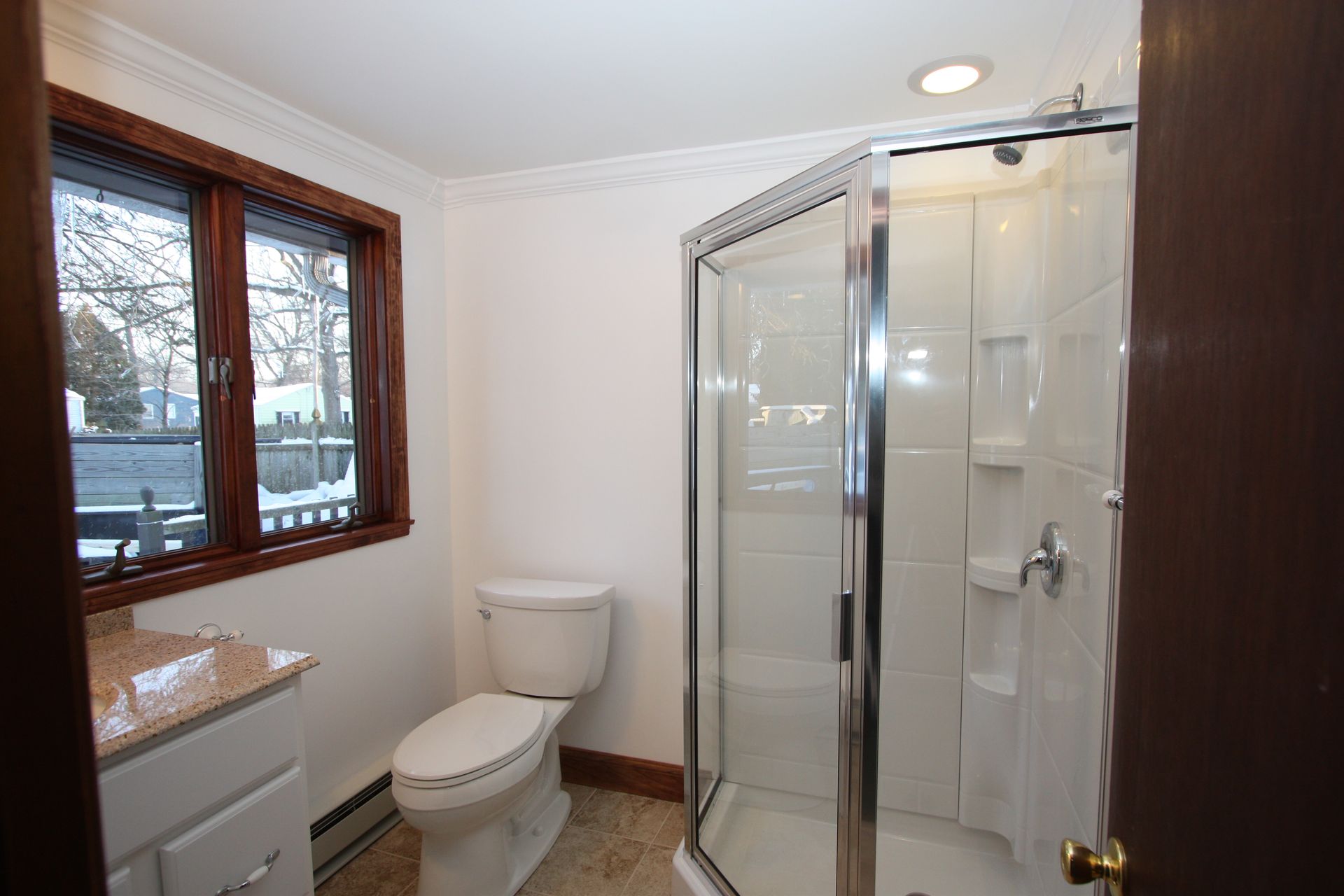A bathroom with a toilet, sink, and shower.