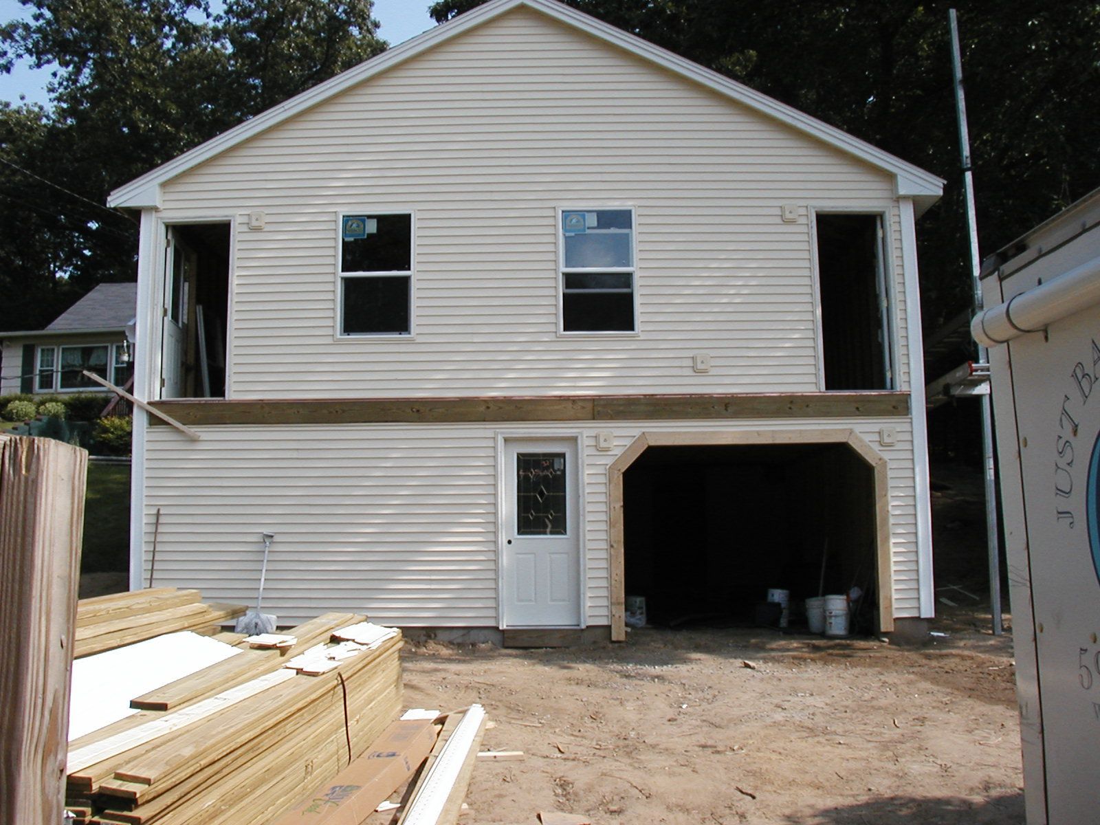 A large white house with a garage underneath it.