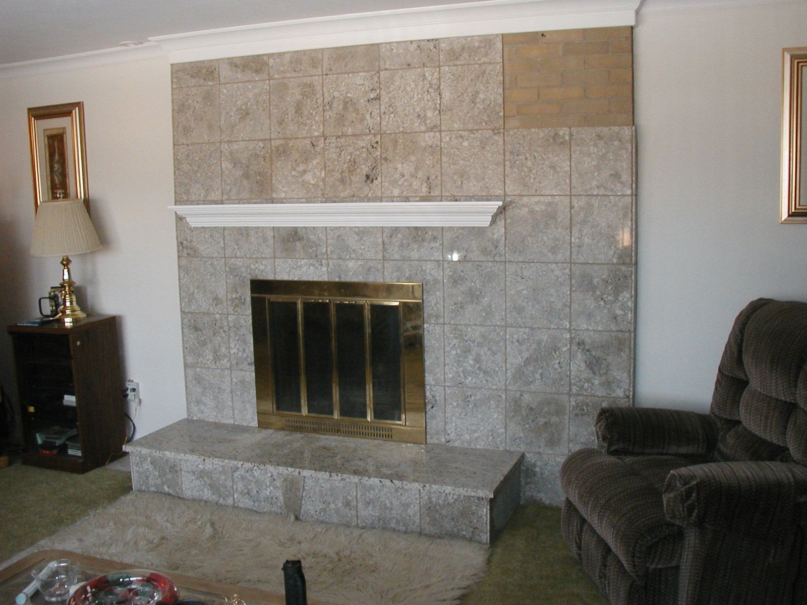 A living room with a fireplace and a chair.