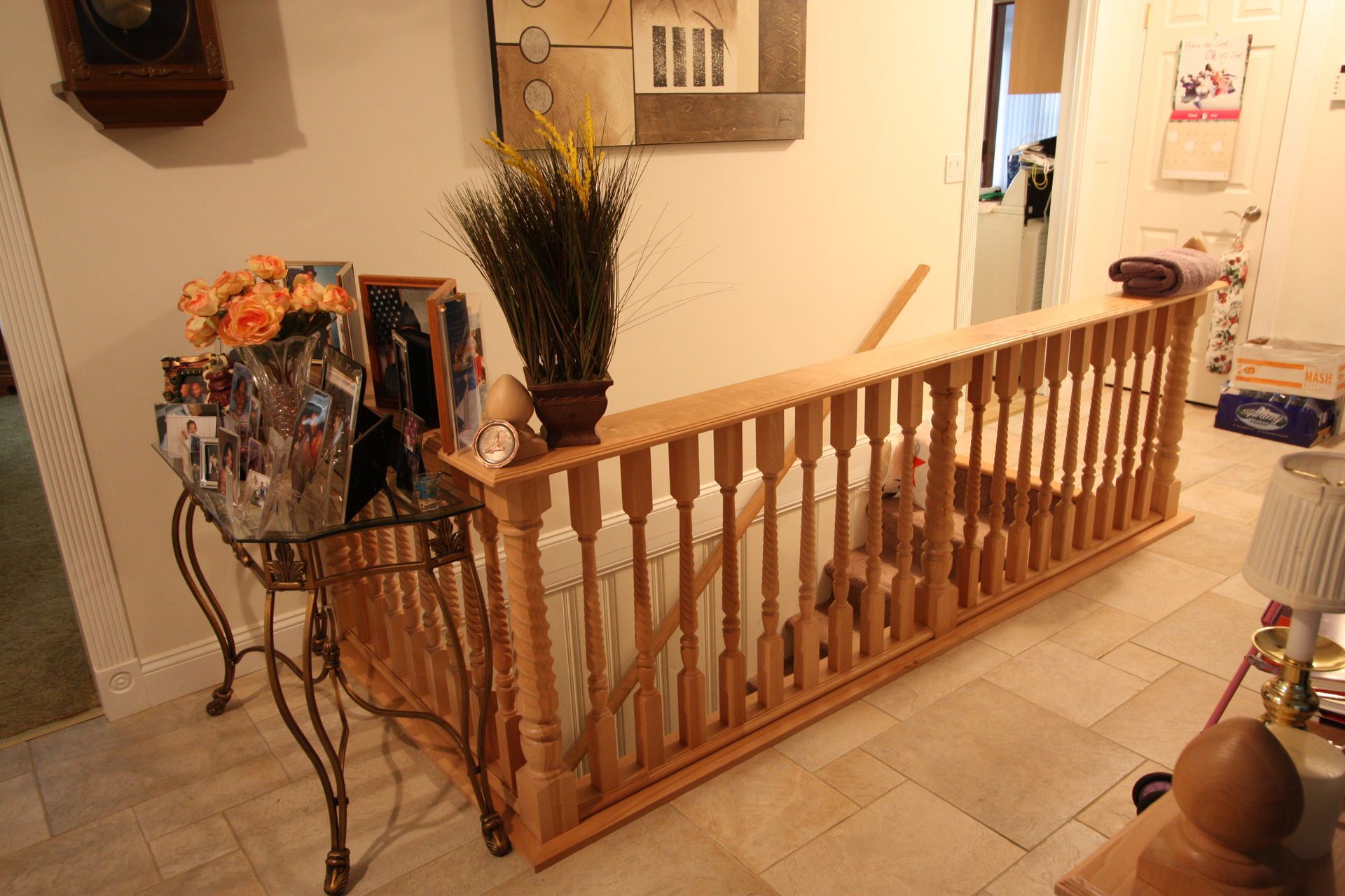 A living room with a wooden railing and a clock on the wall.