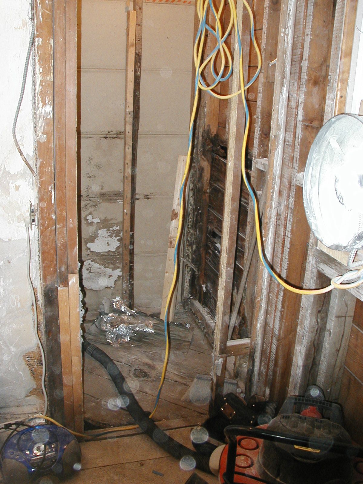 A vacuum cleaner is sitting in a room with a lot of wires.