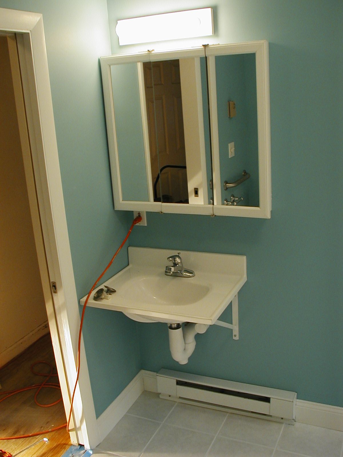 A bathroom with a sink and a mirror above it.