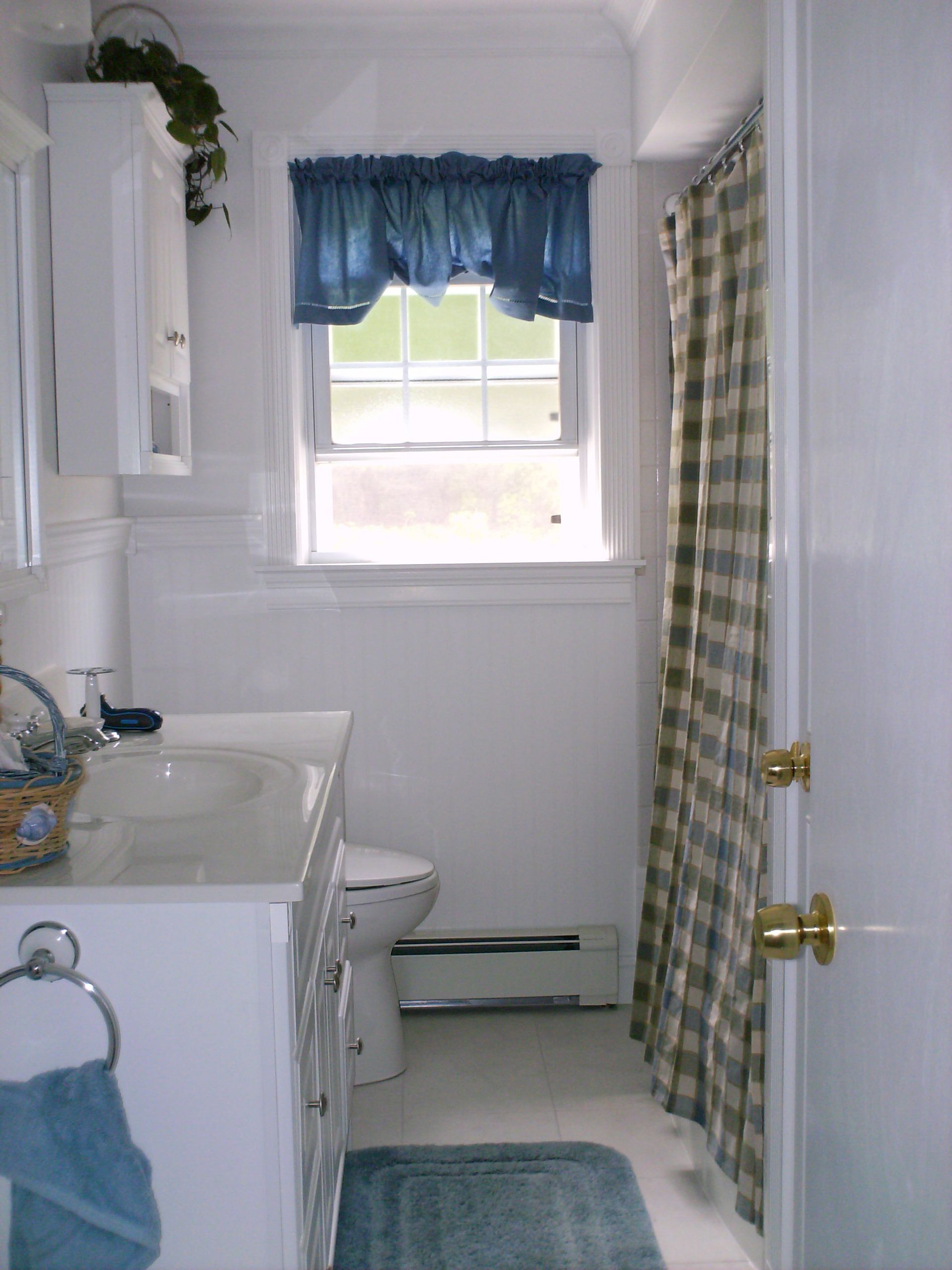 A bathroom with a toilet, a sink, and a window.
