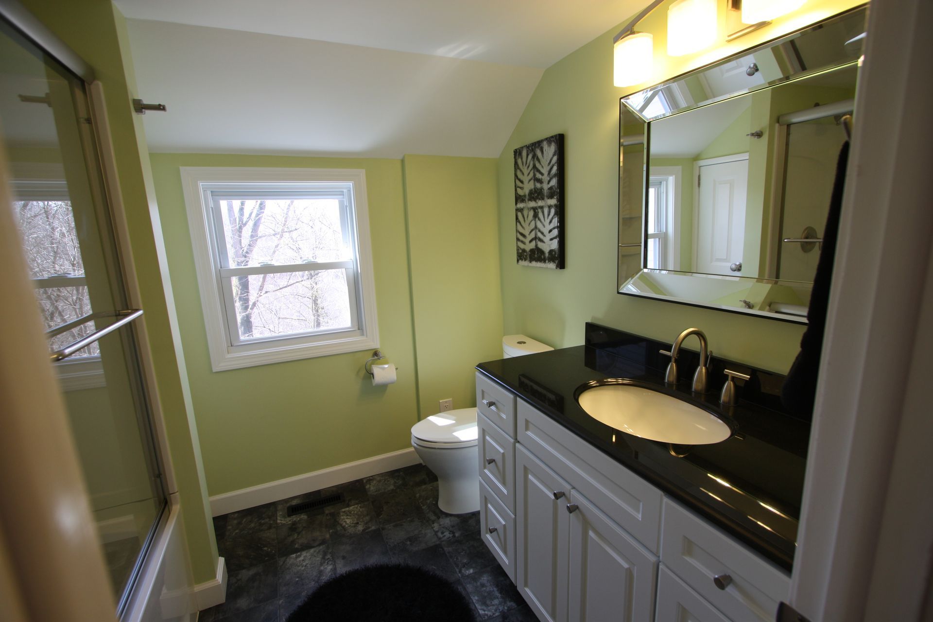 A bathroom with a toilet, a sink, and a mirror.