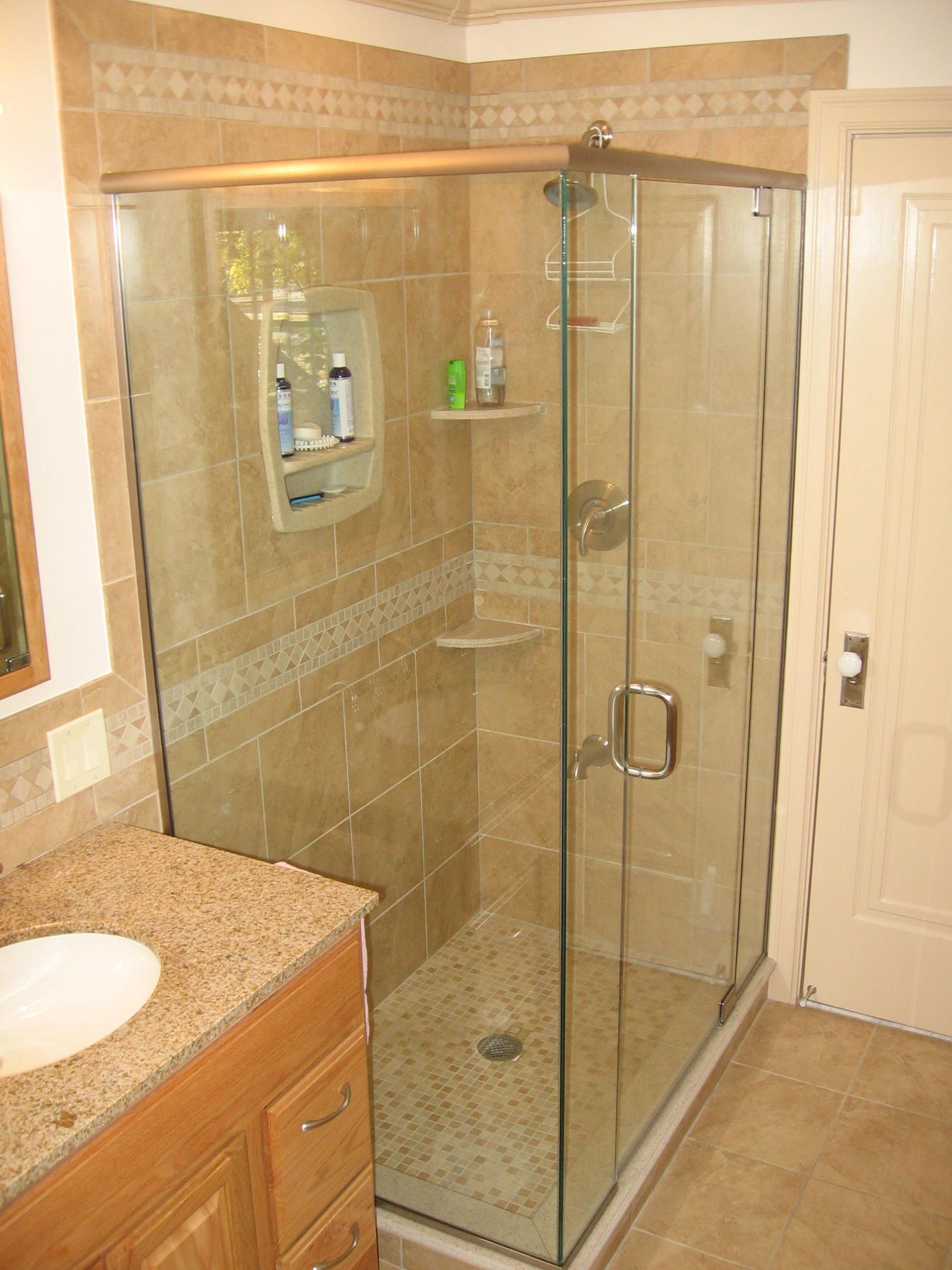 A bathroom with a walk in shower and a sink.
