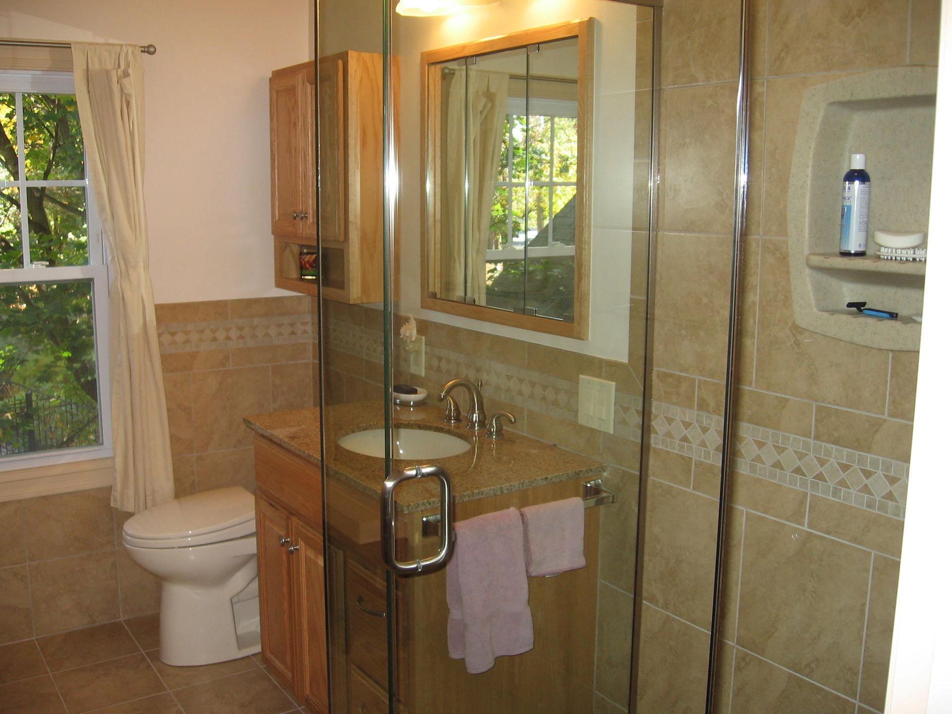 A bathroom with a toilet a sink and a shower.