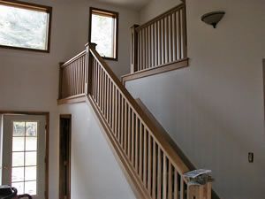 A hallway with a staircase and flowers on the floor.