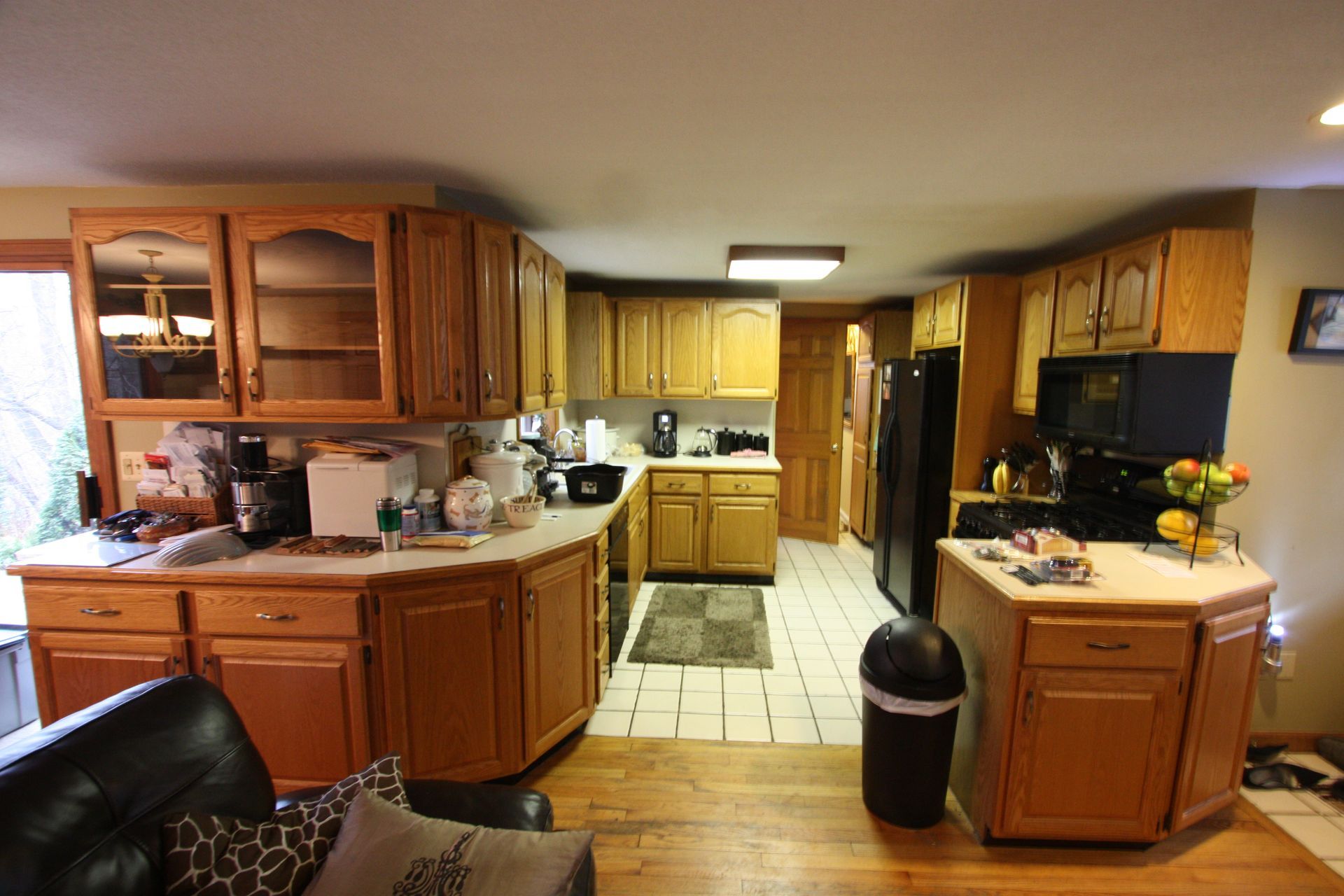 A kitchen with wooden cabinets and a black refrigerator.