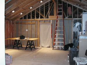 A room with a ladder and a table in it.