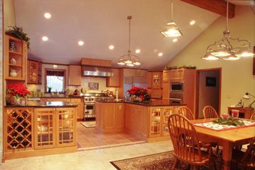 A kitchen with a table and chairs and a wine rack.
