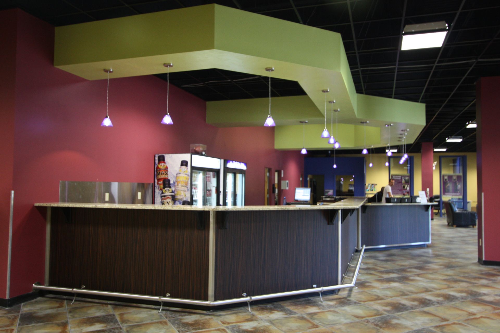A bar in a restaurant with a red wall and green ceiling.