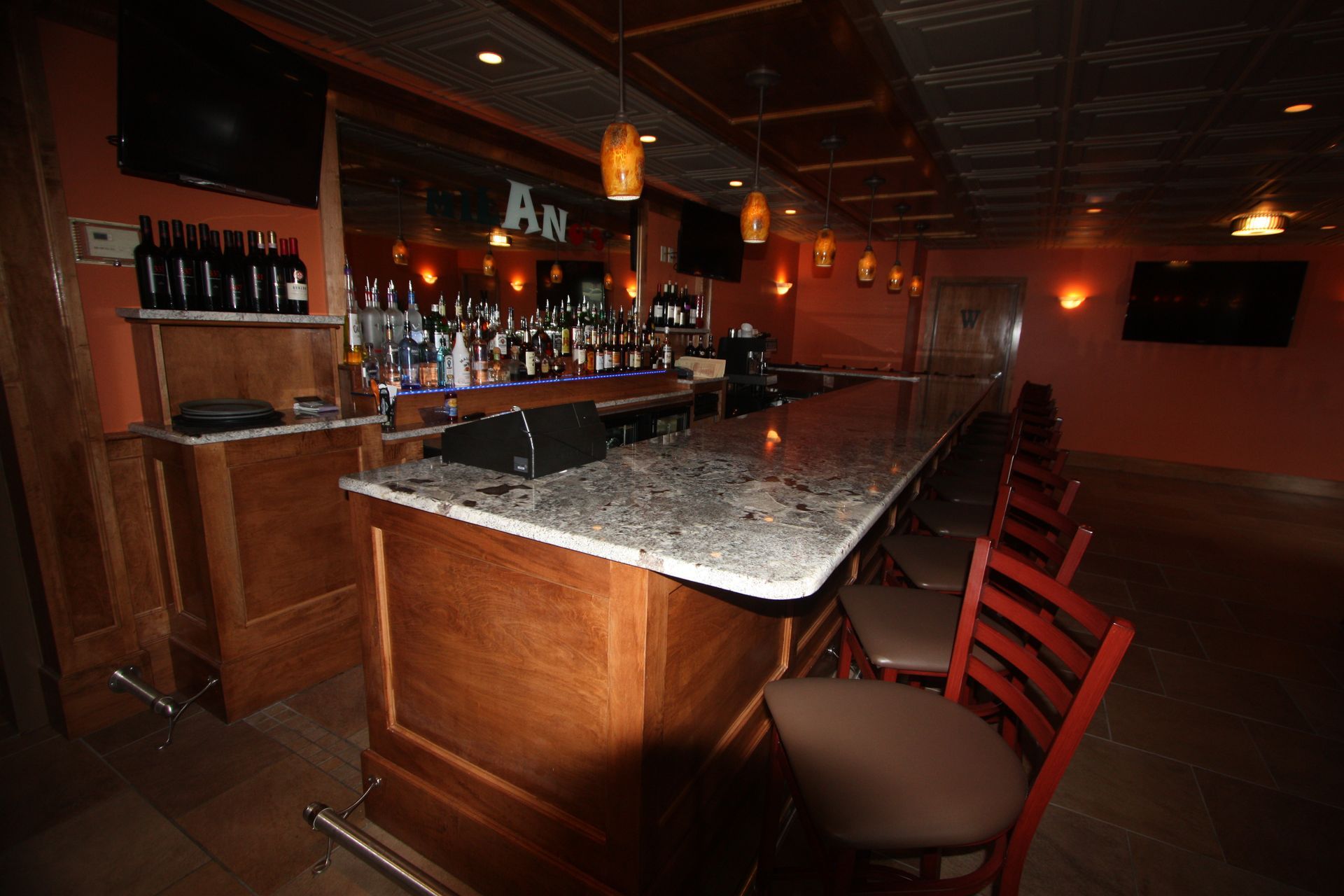 A long bar in a restaurant with a sign that says a.j.