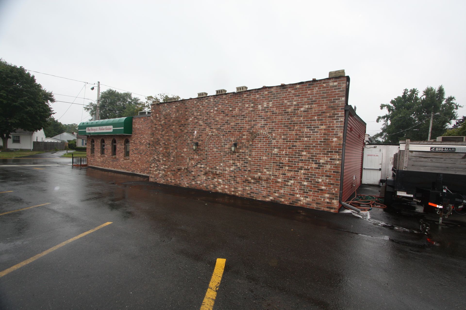 A tow truck is parked in front of a brick building.