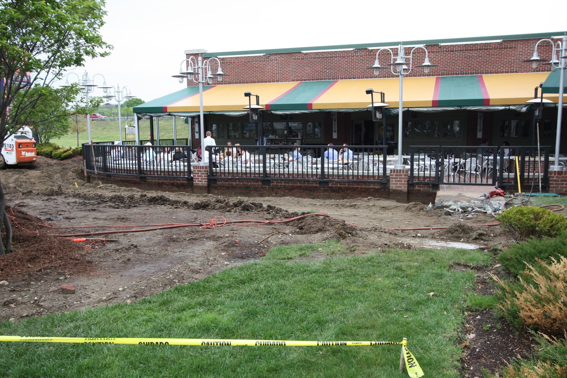 A brick building with a green and yellow awning is being remodeled.