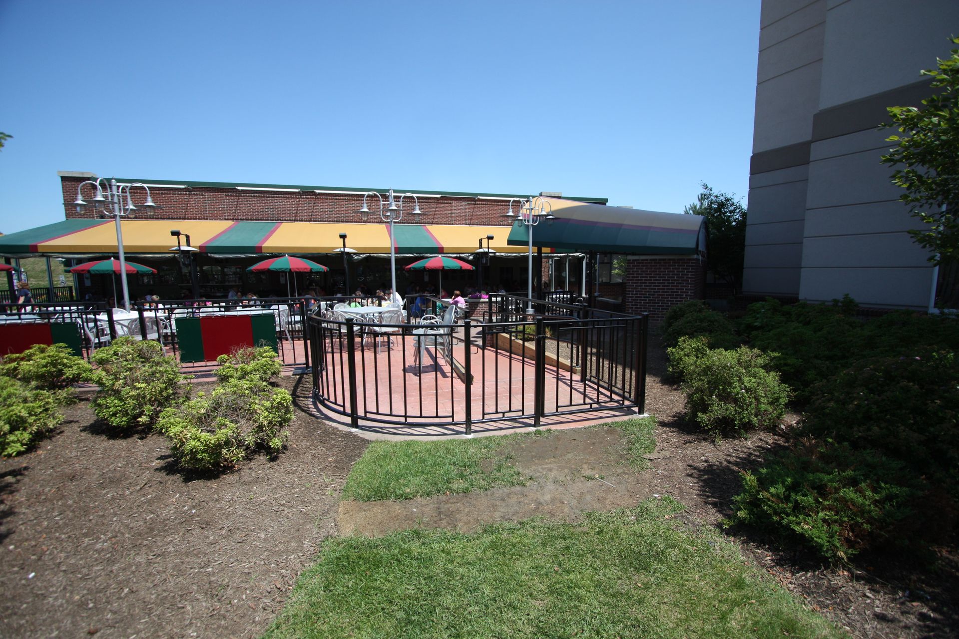 A restaurant with tables and umbrellas outside on a sunny day.