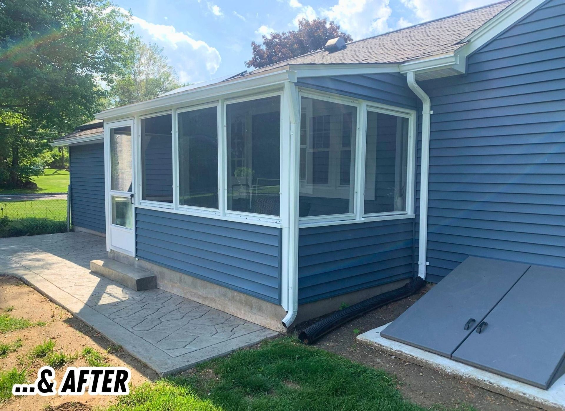 Blue house sunroom addition with white trim, shown in an after-renovation view
