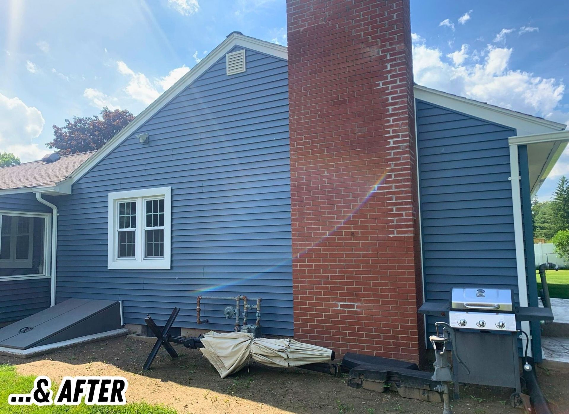 Backyard exterior of a blue house with a brick chimney, patio items, and an after label in the corner