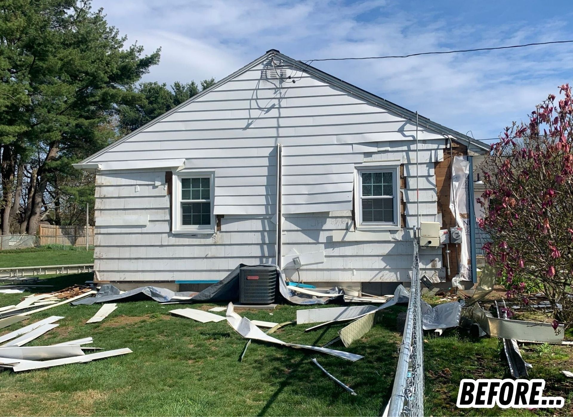 Damaged white house with torn siding and debris in the yard, labeled BEFORE.