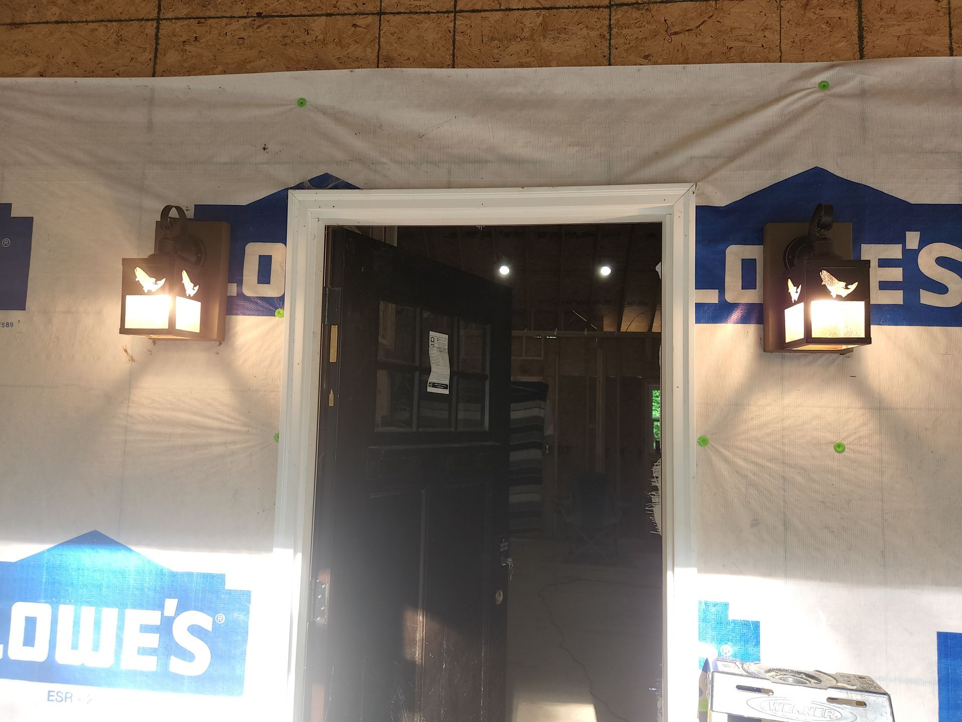 Lowe's storefront entrance under construction, with blue branding and wall lights on either side