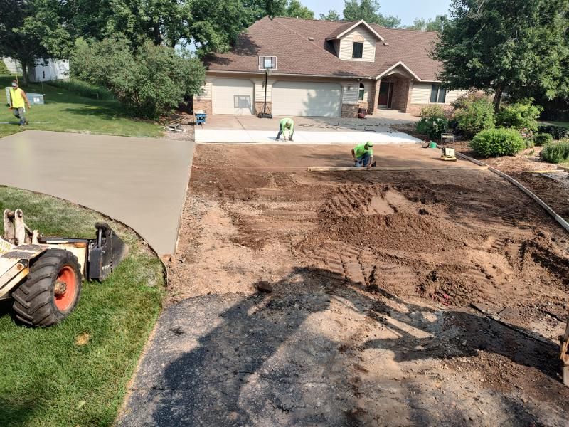 A concrete driveway is being built in front of a house.