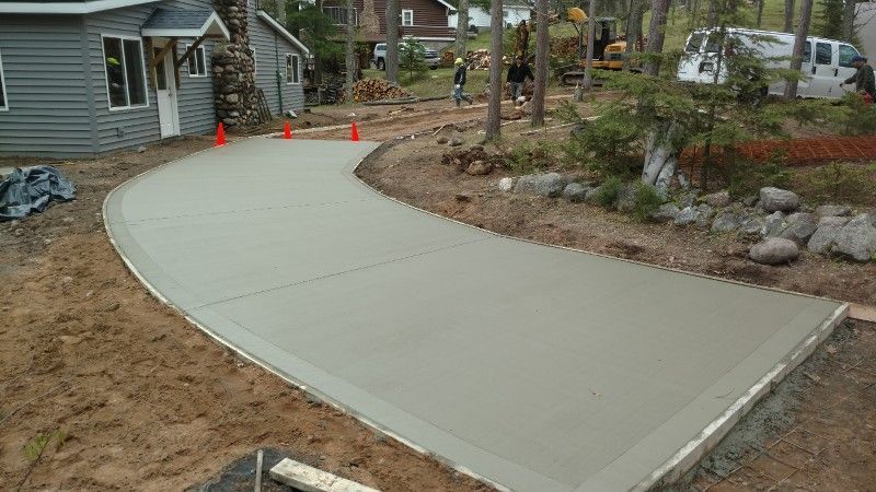 A concrete driveway is being built in front of a house.