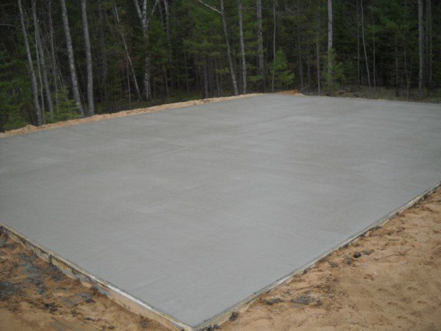 A large concrete slab is sitting in the middle of a dirt field.