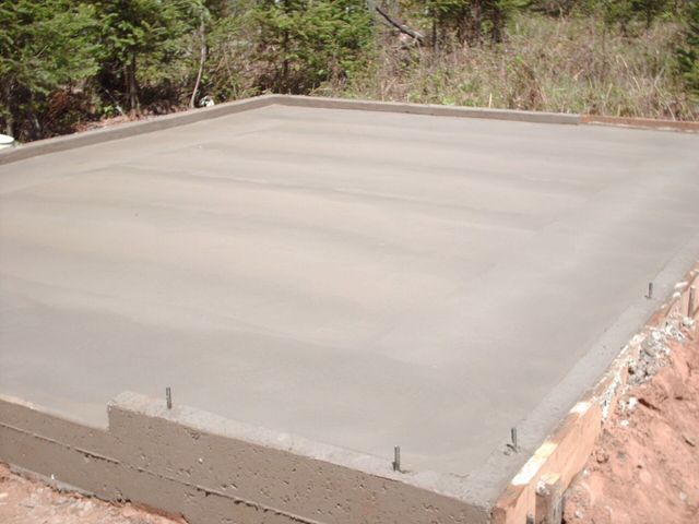A concrete floor is being built in a field.