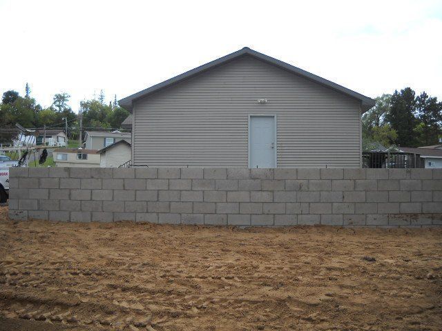 A house with a brick wall in front of it