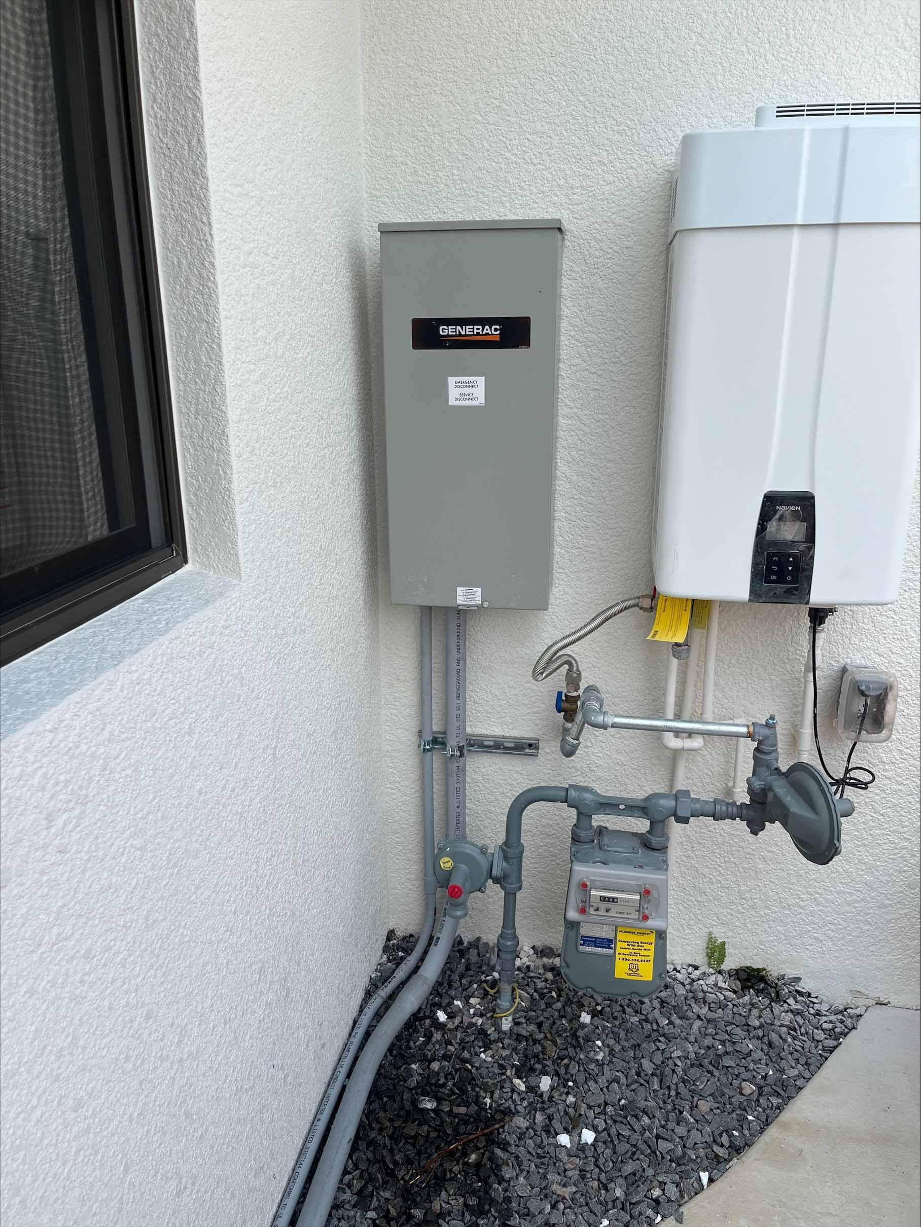 Gray electrical box and water heater mounted on a stucco wall next to a gas meter.