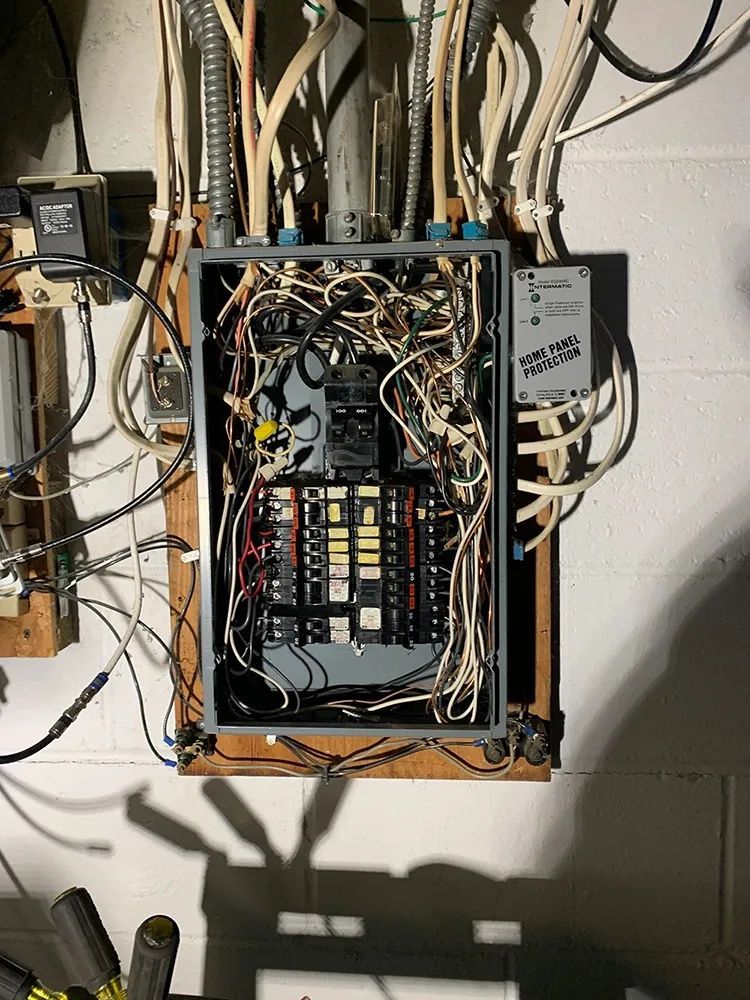 Electrical panel with numerous wires and conduits.