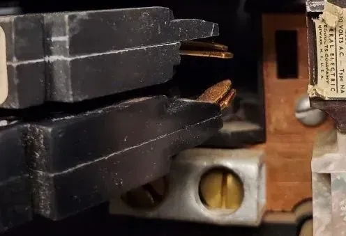 Close-up of electrical components; black plastic housings with copper contacts.