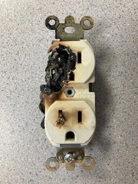 Significant melting on duplex outlet, which is an immediate fire hazard.