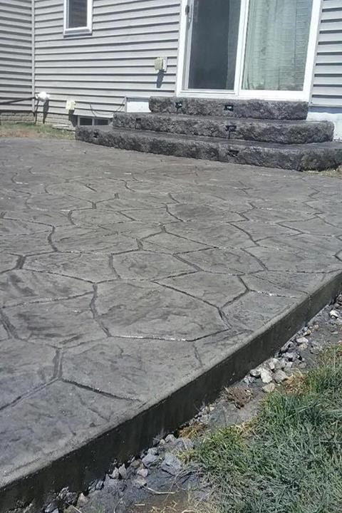 A concrete patio with stairs leading up to a house.