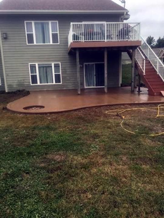A large house with a patio and stairs in the backyard.