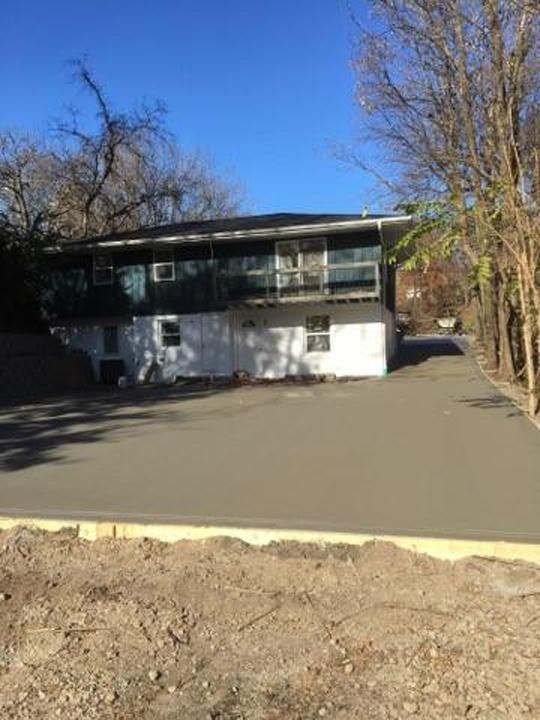 A house with a concrete driveway in front of it.
