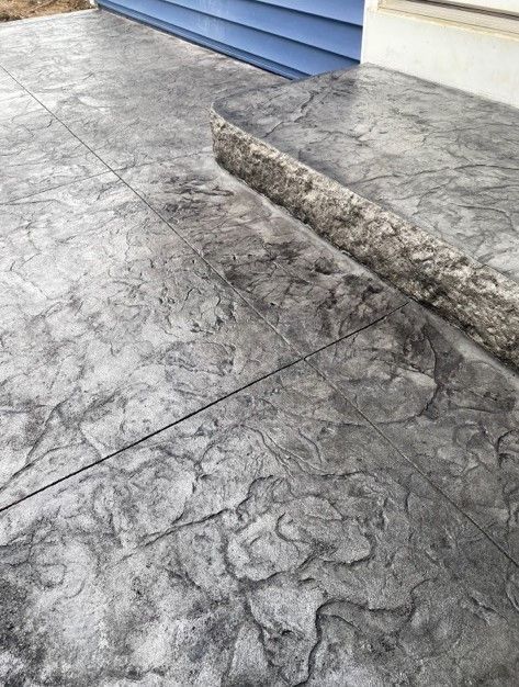 A close up of a concrete walkway next to a house.