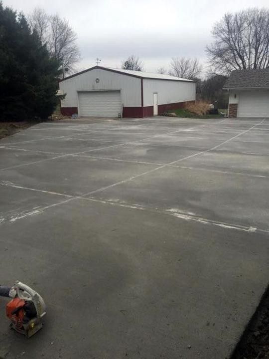 A large concrete parking lot with a garage in the background.