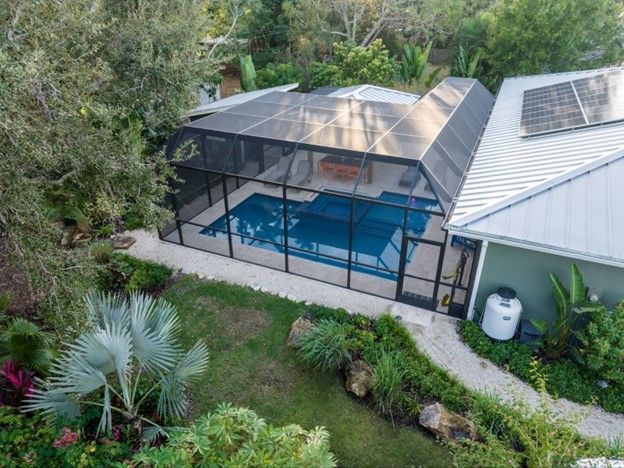 A newly built swimming pool with a pool cage around it