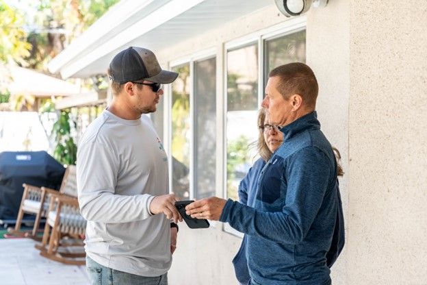 Member of pool installation team talking with clients