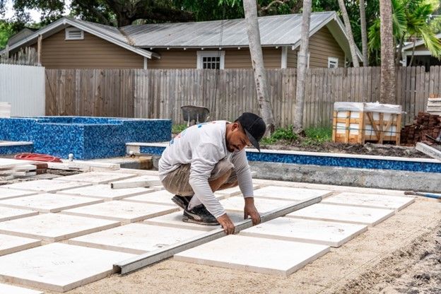 A pool builder is installing the deck for a new pool