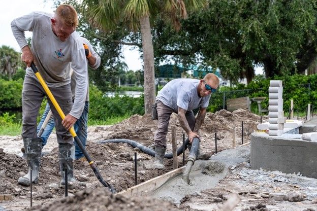Two men are working in the dirt on a construction site.