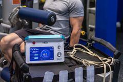 A man is sitting on a machine in a gym.