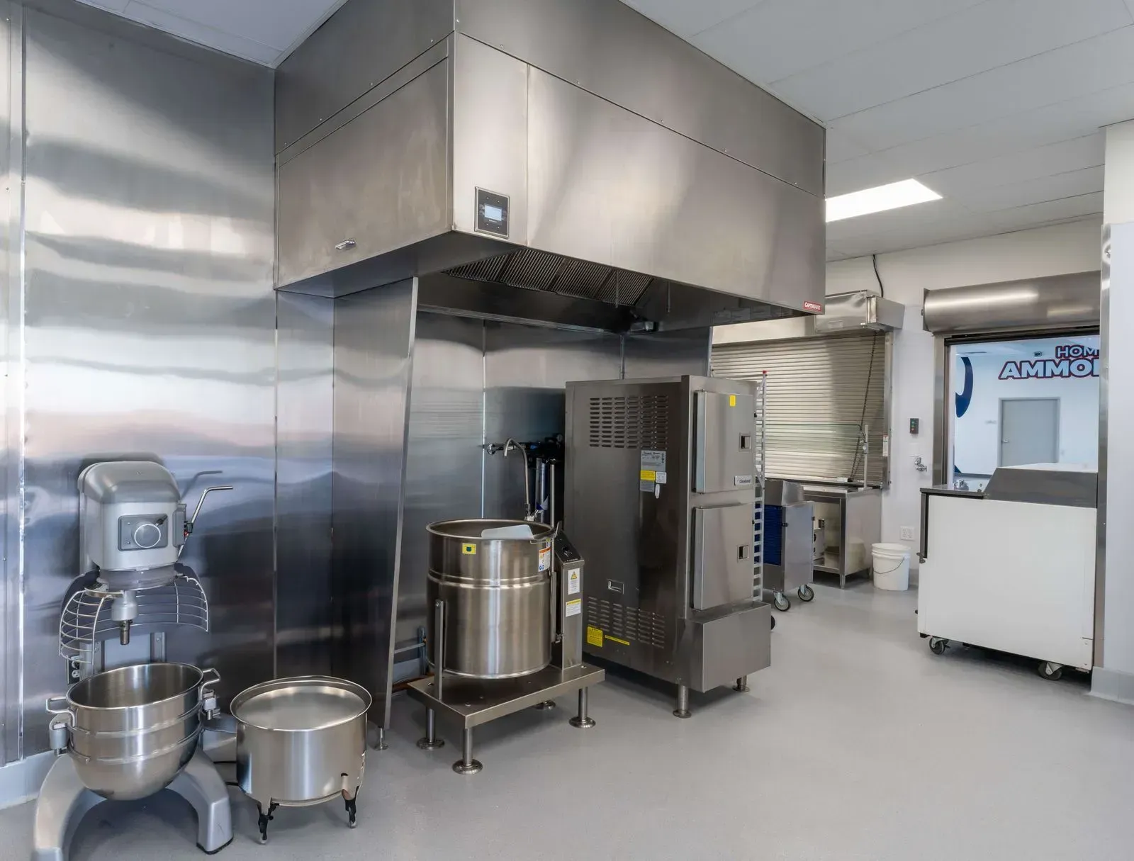 A kitchen with stainless steel appliances and mixers.