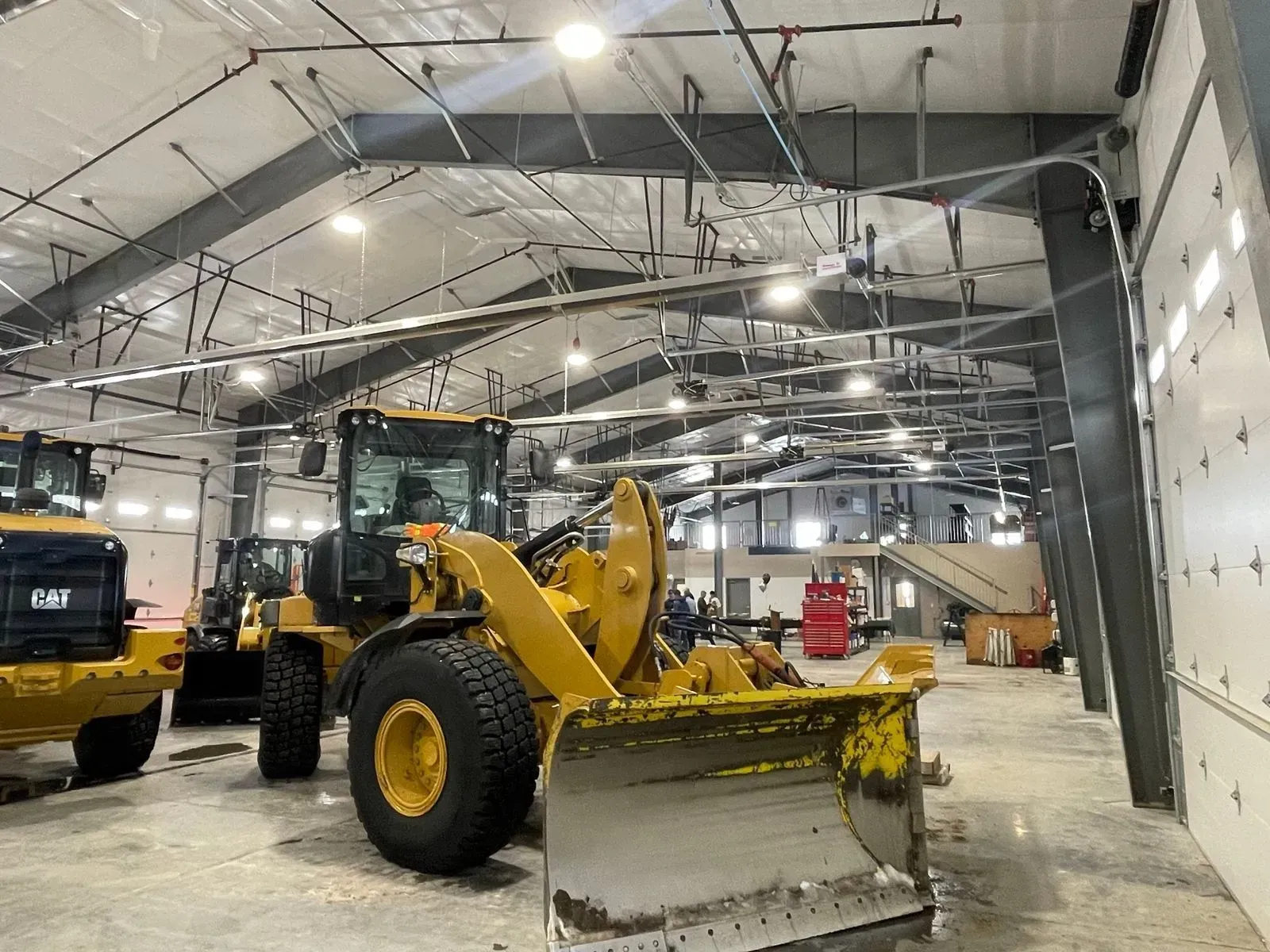 Yellow construction loader inside a large warehouse