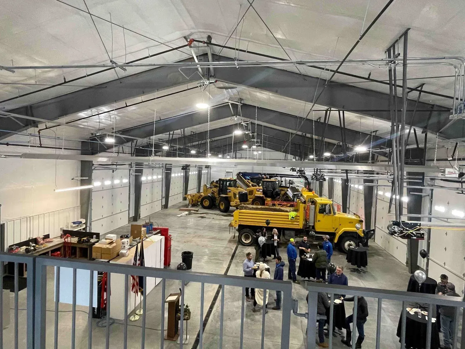 Interior of a large maintenance garage with heavy machinery and people