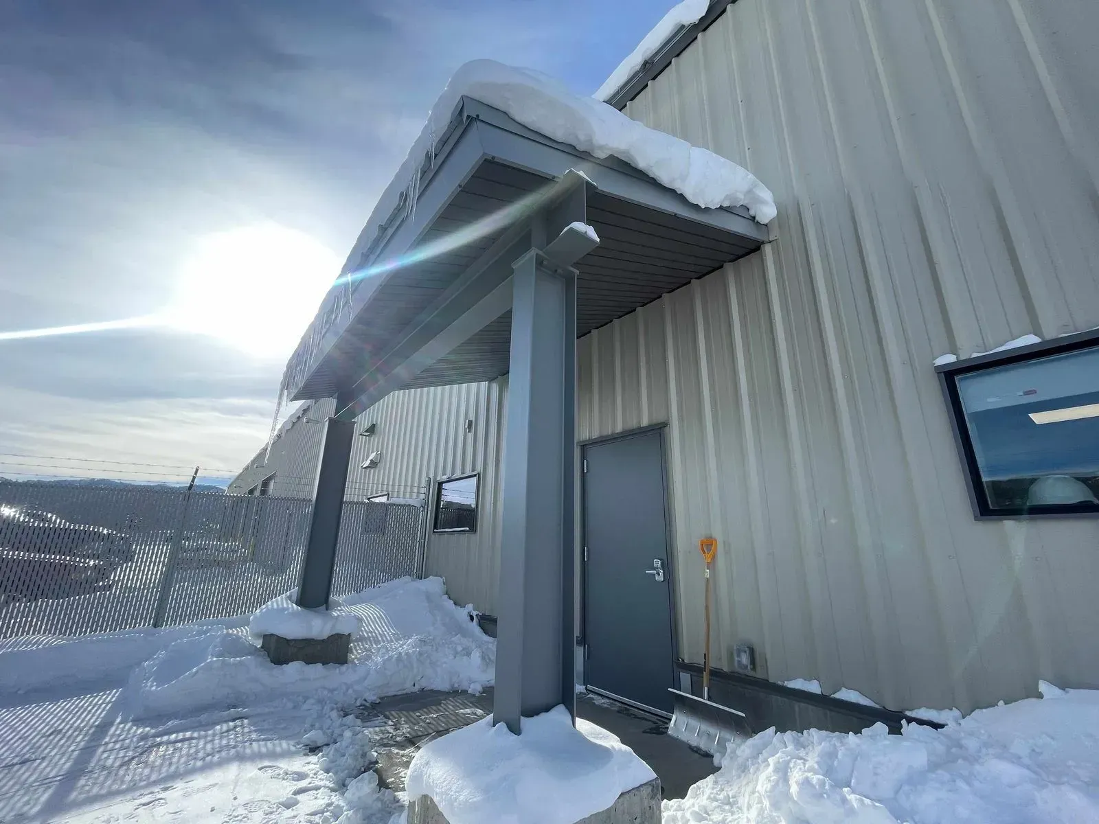 Snow-covered entrance to a metal-sided building